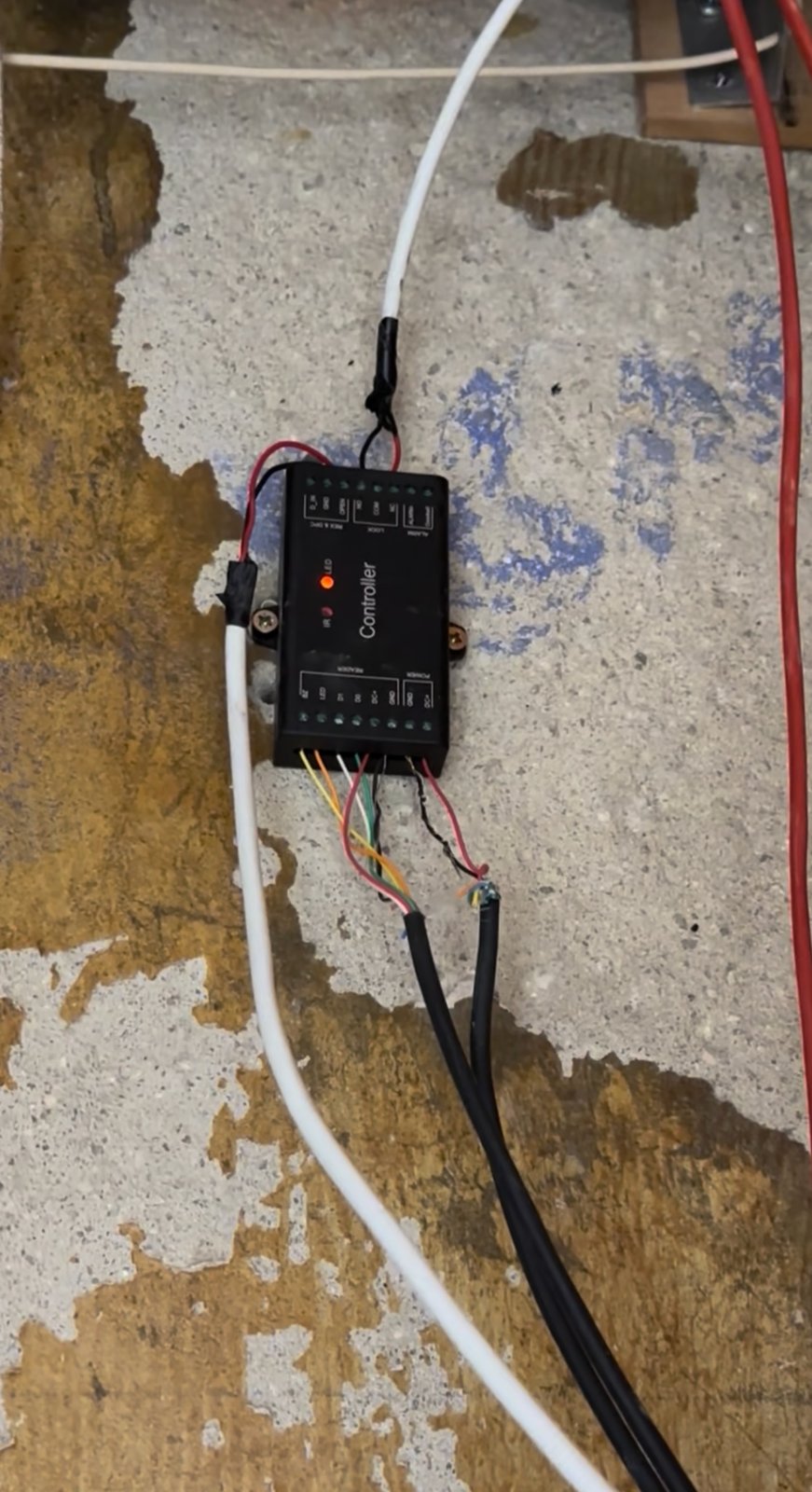 A UHPPOTE micro-controller screwed to a concrete wall